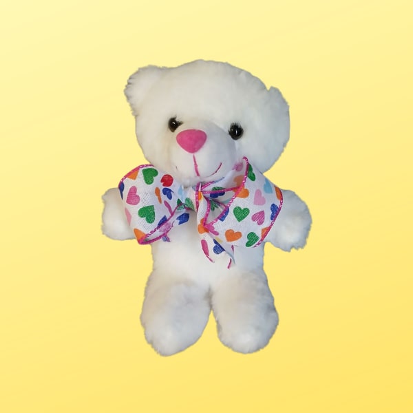 White teddy bear with a colorful heart-pattern bow on a yellow background