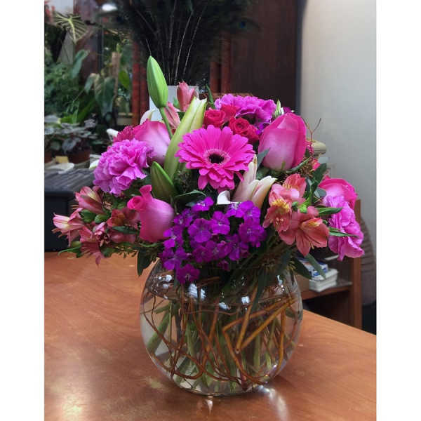 Pink and purple mixed bouquet in a round glass vase