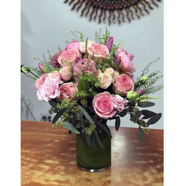 Pink rose bouquet in a green glass vase