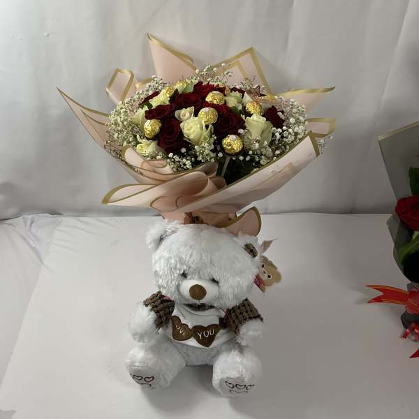 Bouquet of red and white roses with a teddy bear below