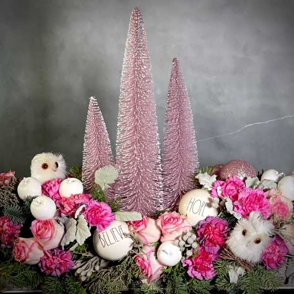 Pink floral arrangement with decorative trees, owls, and white ornaments