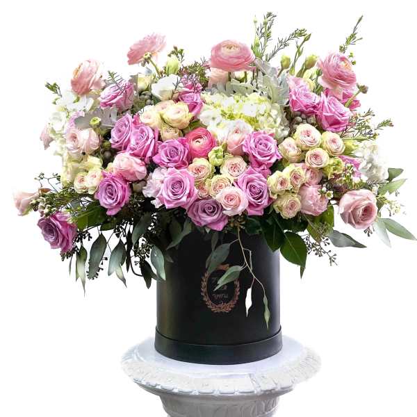 Large pink and white rose arrangement in a black hatbox