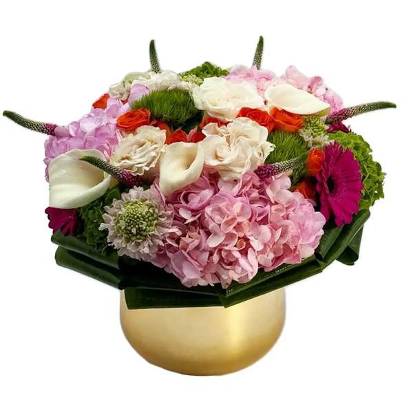 Pink and white floral arrangement in a gold vase