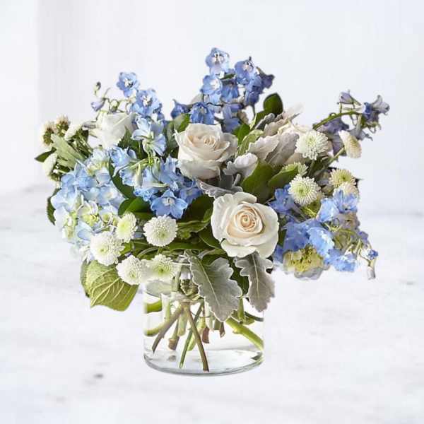 Blue and white flower arrangement in a clear glass vase
