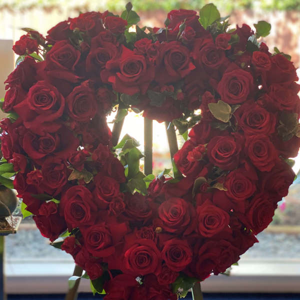 Heart-shaped arrangement of red roses on an easel