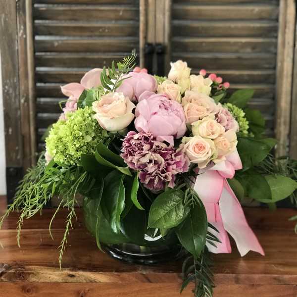 Pink and cream rose bouquet with green hydrangea in a glass vase