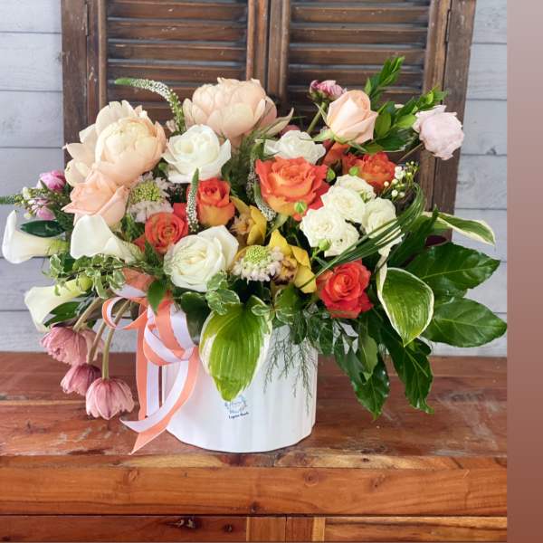 Mixed bouquet in a white hatbox with peach, white, and coral blooms