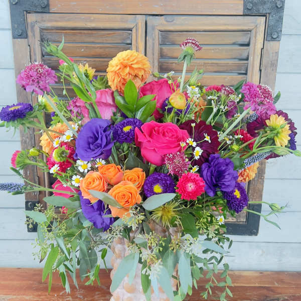Bright mixed bouquet in a textured vase
