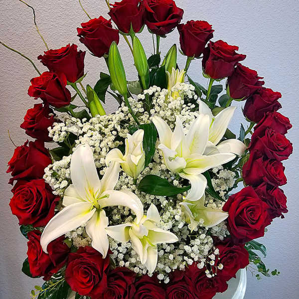 Red roses and white lilies arranged in a white vase