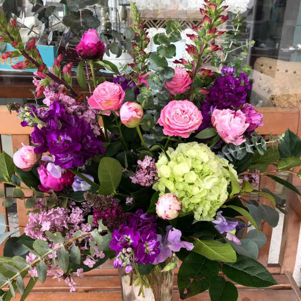 Mixed pink and purple floral arrangement in a clear glass vase