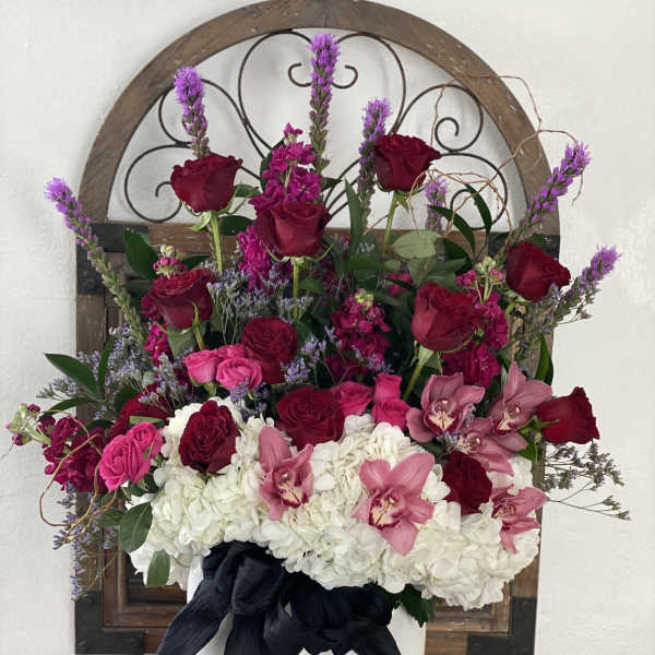 Pink and red roses with white hydrangeas in a white vase