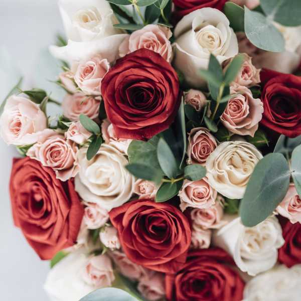 Bouquet of red, blush, and white roses with eucalyptus
