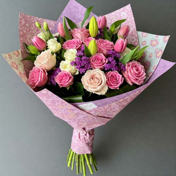 Pink and cream rose bouquet with tulips wrapped in patterned paper