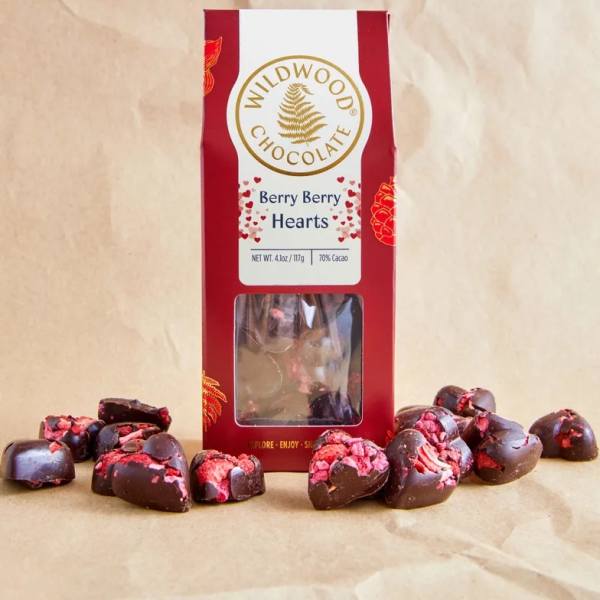 Box of berry chocolate hearts with pieces scattered around it