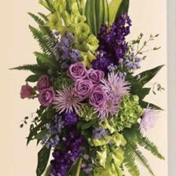 Tall purple and green floral spray on a white easel