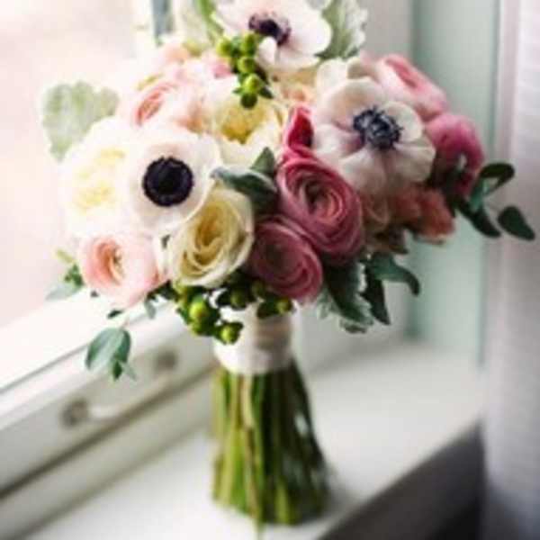 Bouquet of pink, white, and yellow flowers in a hand-tied wrap