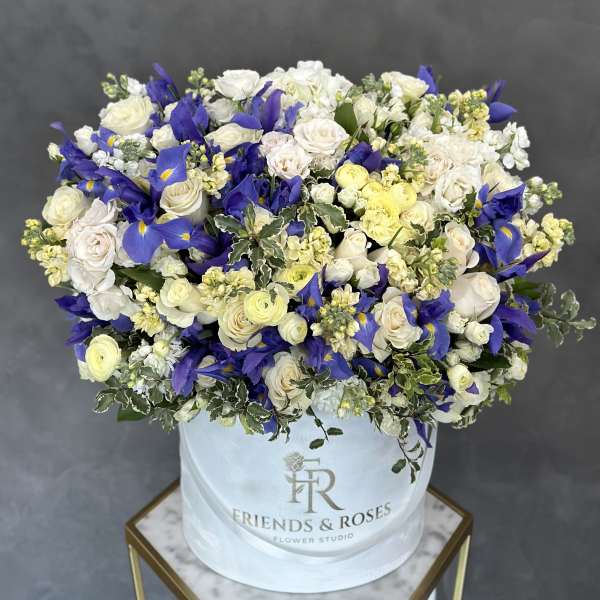 Large bouquet of white and blue flowers in a white hat box