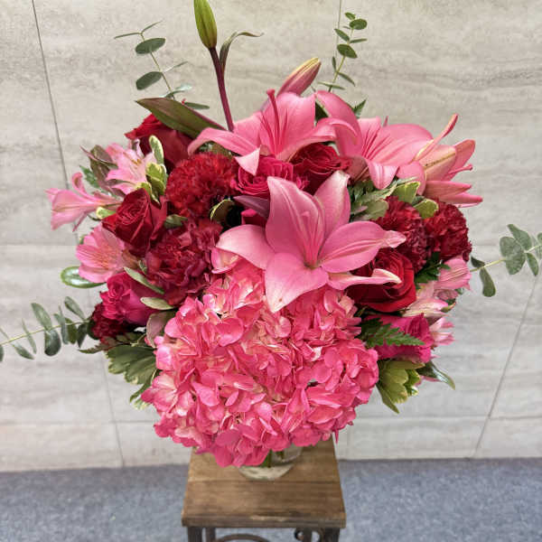 Pink and red floral arrangement in a clear glass vase