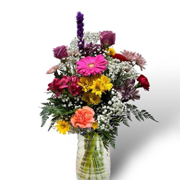 Mixed bouquet of colorful flowers in a clear glass vase