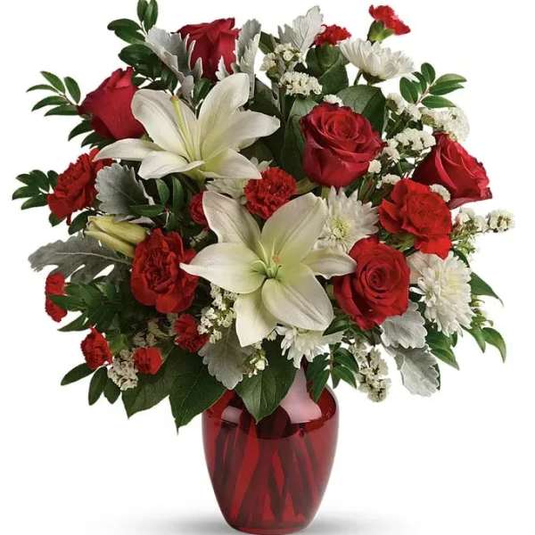 Red roses and white lilies in a red glass vase