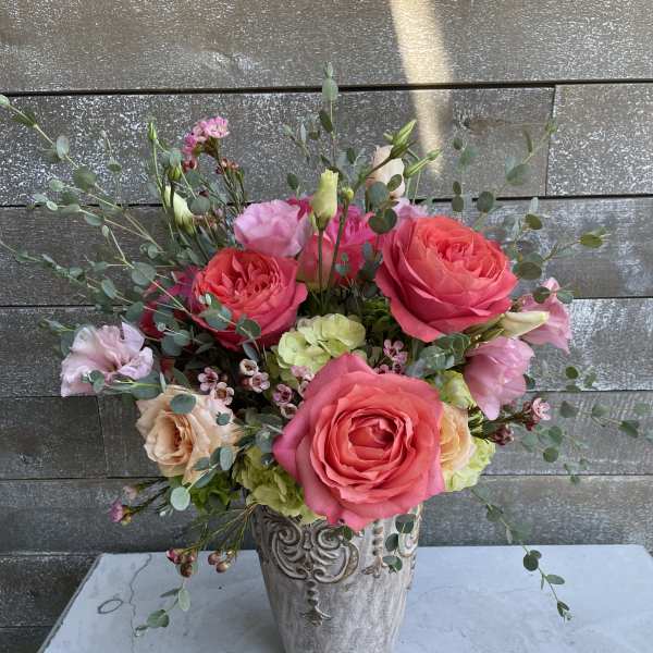 Pink and peach roses arranged in a decorative vase