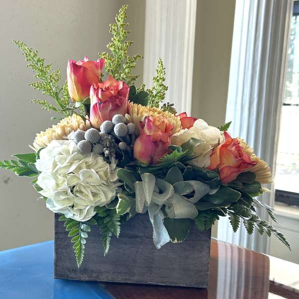 Bouquet of roses and hydrangeas in a wooden box with a ribbon