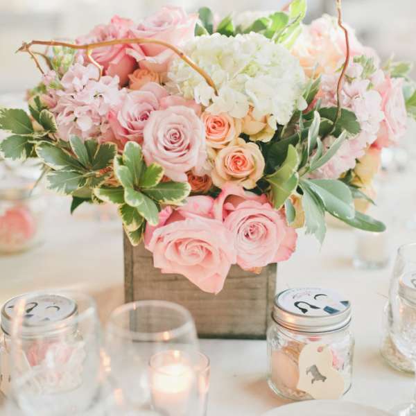 Pink and white floral centerpiece in a wooden box on a table