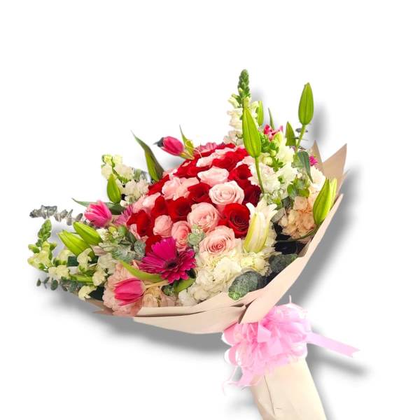 Bouquet of red and pink roses with lilies and white flowers in paper wrap
