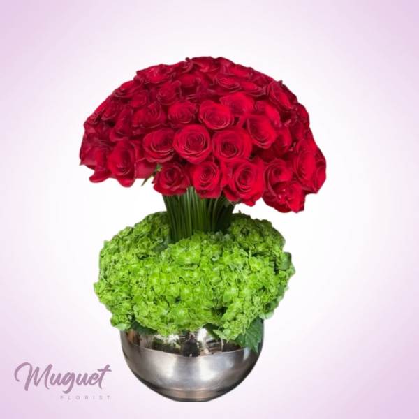 Red rose arrangement with green hydrangeas in a silver vase