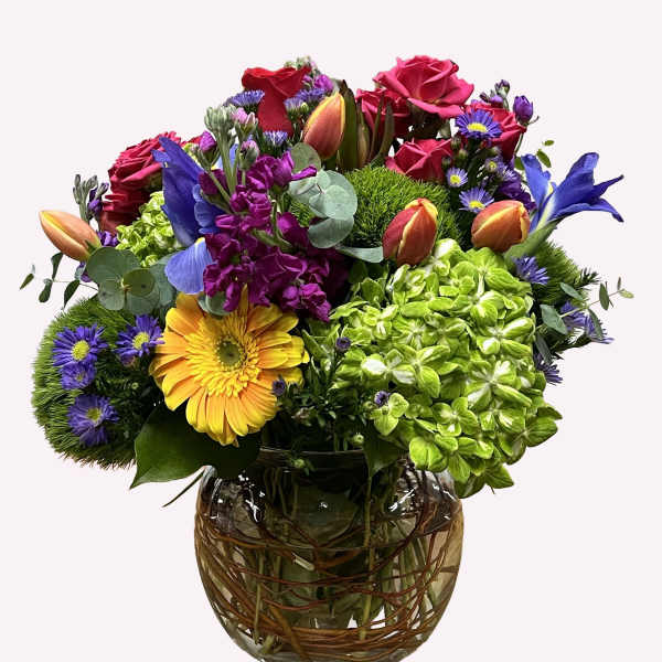 Mixed bouquet of roses, hydrangea, and daisies in a glass vase