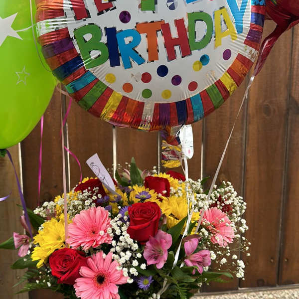 Birthday bouquet with a large balloon and mixed flowers in a glass vase