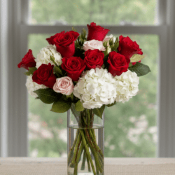 Red roses and white hydrangeas in a clear glass vase