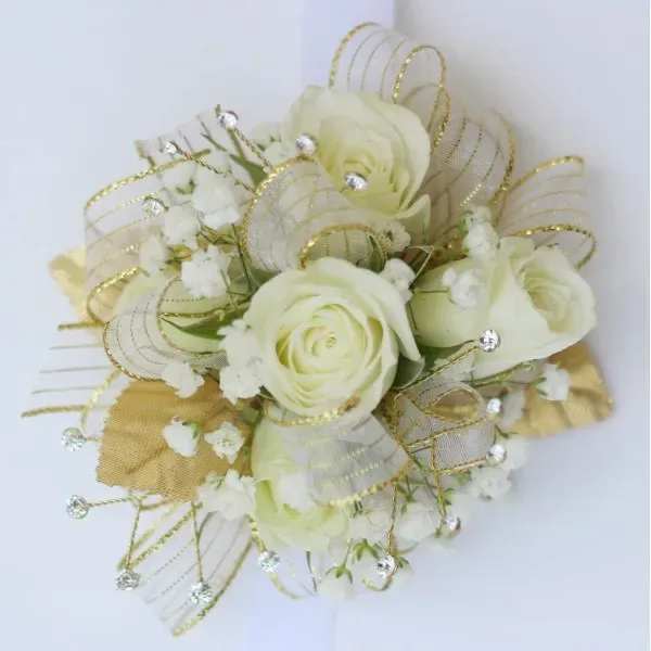 Ivory rose wrist corsage with white filler flowers, gold ribbon, and crystal accents