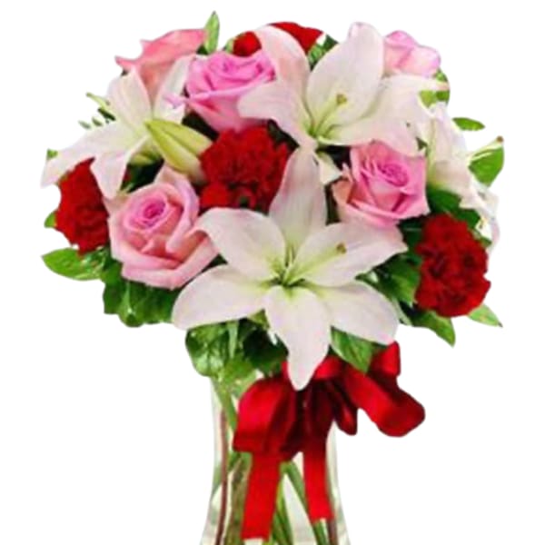 Pink roses and white lilies in a clear glass vase with a red ribbon