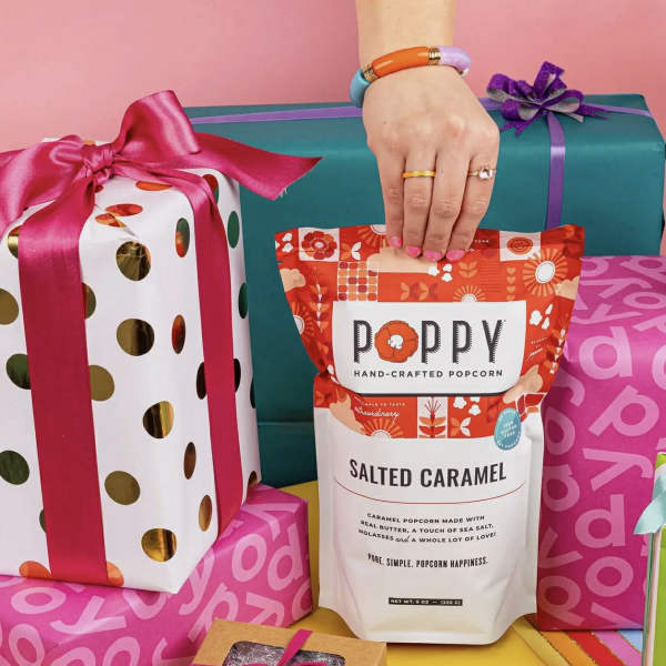 Gift boxes and a bag of salted caramel popcorn with ribbon bows