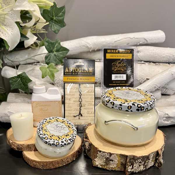 Candles and fragrance products arranged on wood slices with faux flowers