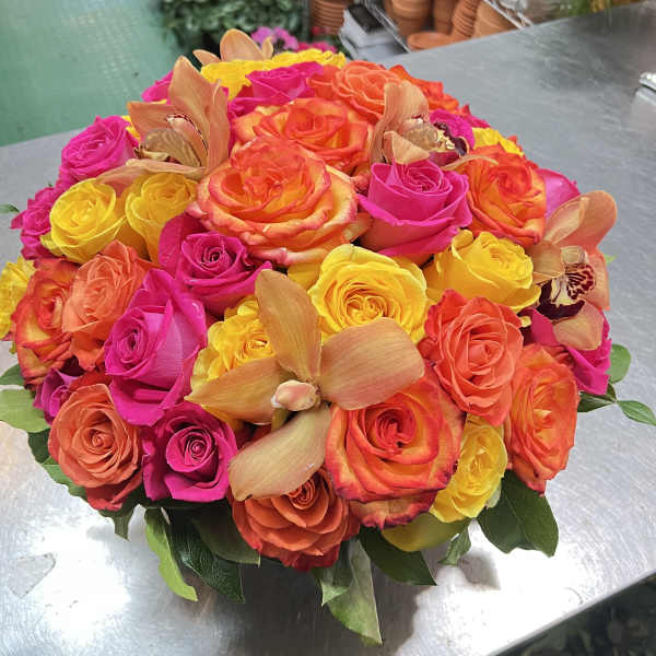 Round bouquet of bright roses with orchid blooms