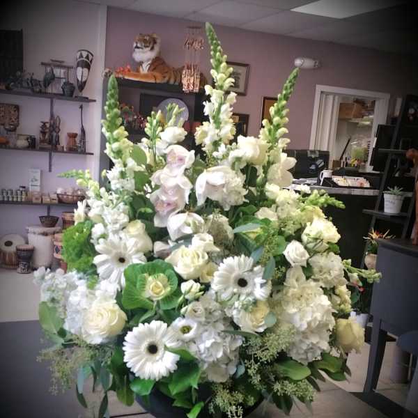 Large white floral arrangement in a black bowl vase