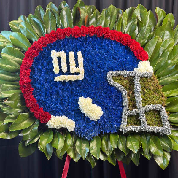 Football-shaped floral tribute with a red border and blue center