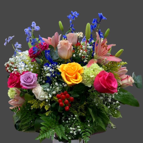 Mixed bouquet with roses, lilies, and blue delphinium in a box