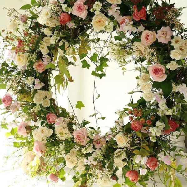 Large circular floral wreath with pink and white roses