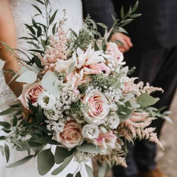 Wedding bouquet of blush roses and white flowers with airy greenery