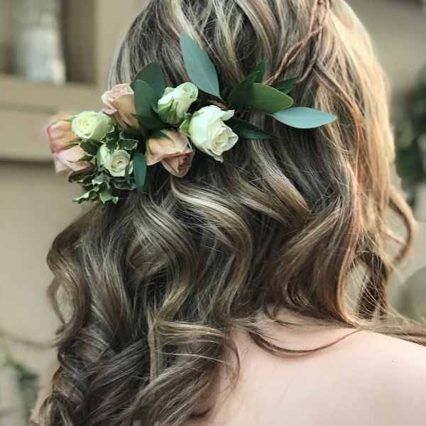 Floral hairpiece with blush and white roses in a woman's hair