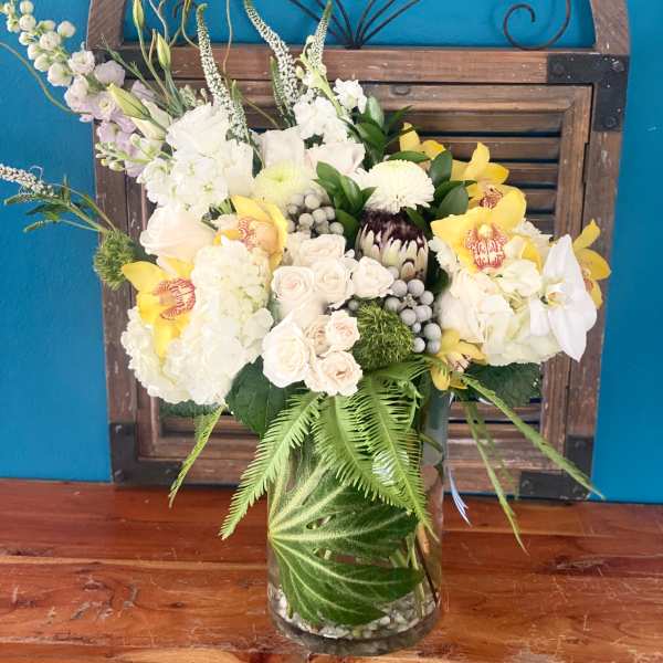 Mixed white and yellow floral arrangement in a glass vase