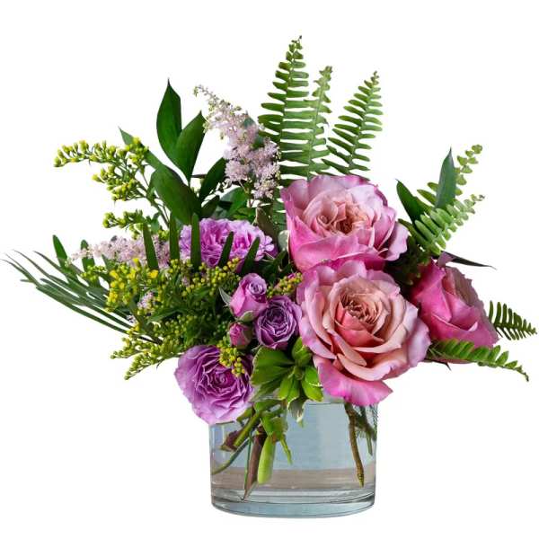 Pink and purple roses arranged in a clear glass vase