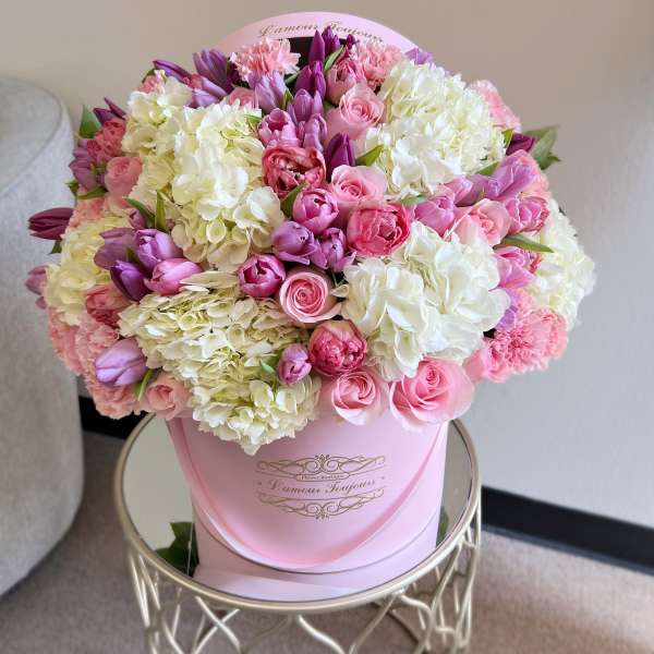 Pink and white bouquet in a round pink hat box