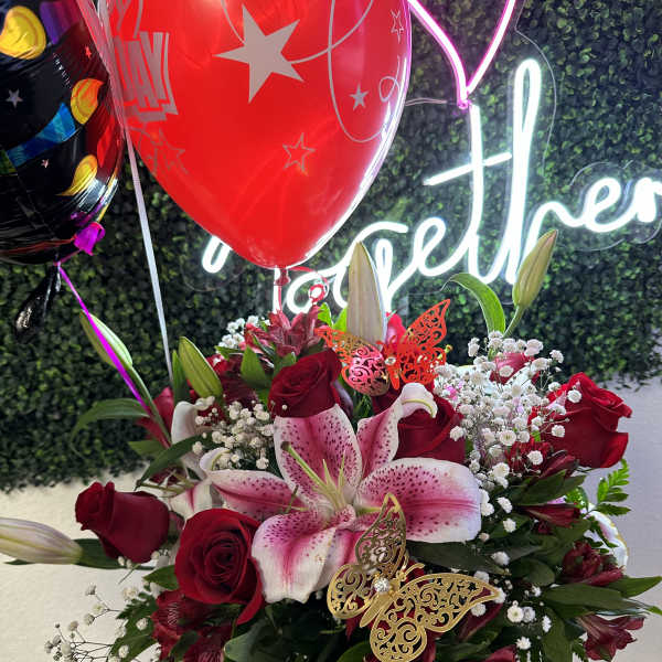 Bouquet of red roses and pink lilies with balloons