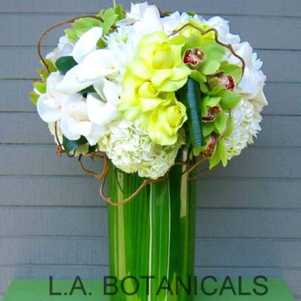 Tall bouquet of white and lime-green flowers in a green vase