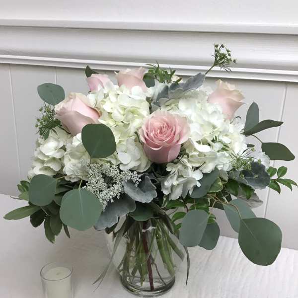 Pink roses and white hydrangeas in a glass vase