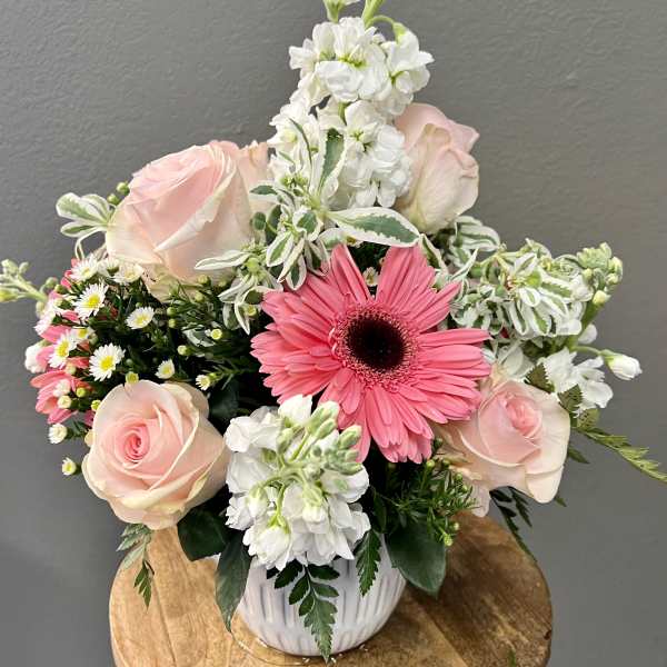 Pink gerbera and roses in a white vase with white blooms